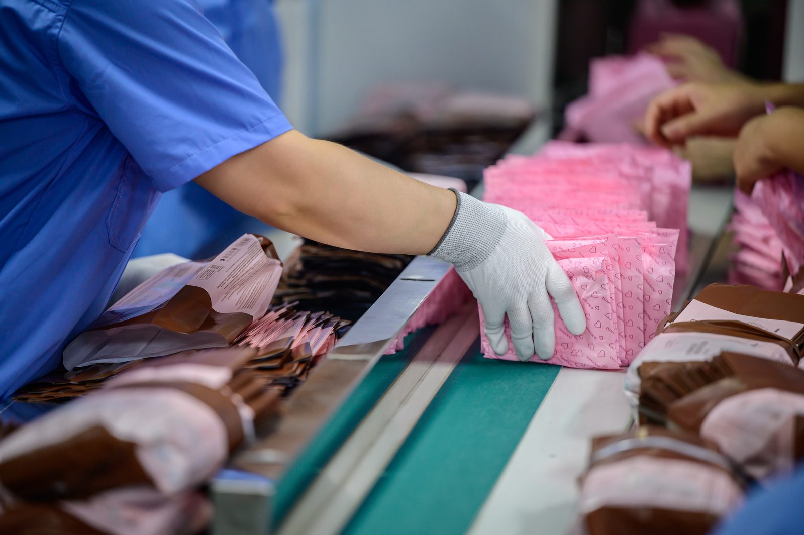 Sanitary pad products moving along the packaging conveyor