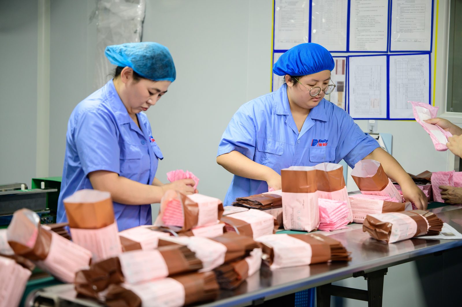 Workers packing sanitary pads at the Dailys manufacturing facility